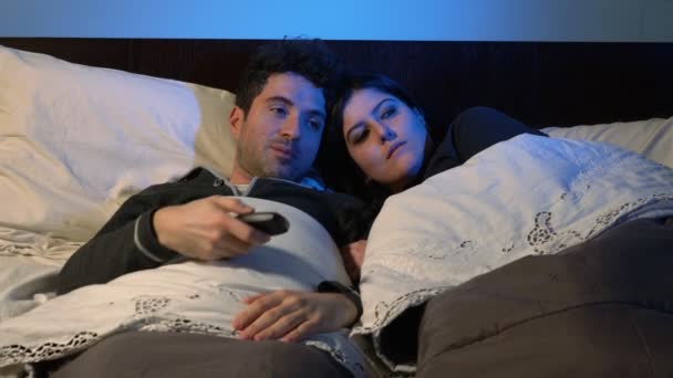 Lächelndes Paar Bett Wechselt Mit Der Fernbedienung Die Kanäle Fernseher — Stockvideo