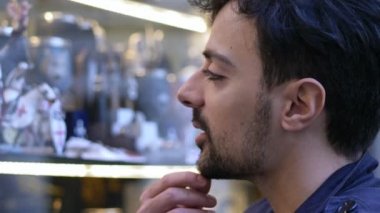 Vitrin izlerken odaklı genç çekici adam