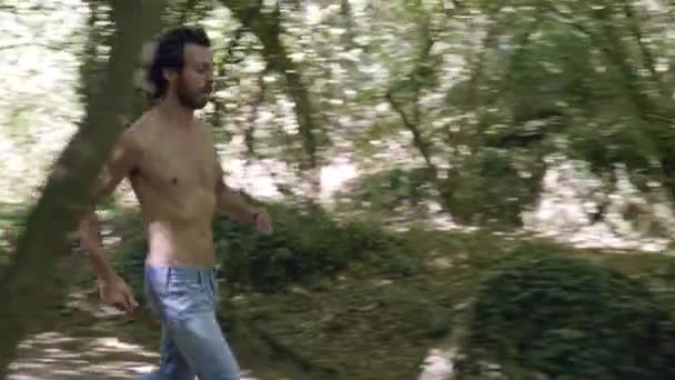 Attraente Giovane Uomo Che Corre Nel Bosco — Video Stock