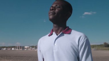 kaygısız, özgürlük, doğa. Genç Afrikalı adam denizin tadını çıkarıyor