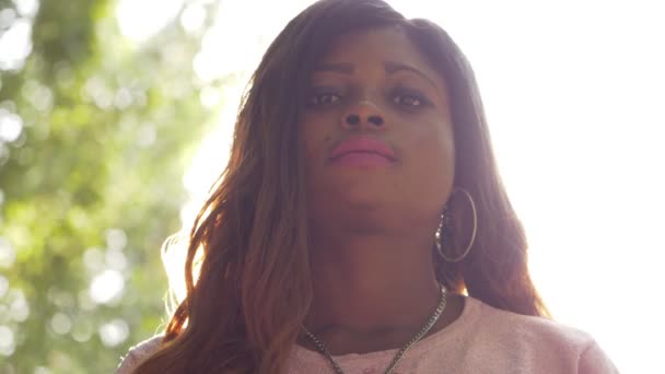 公園の中でカメラを見つめる誇り高い黒人の若いアフリカ人女性 スローモーション — ストック動画