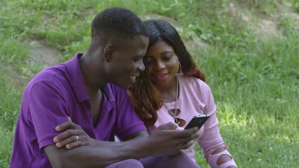 Amantes Africanos Americanos Felizes Olhando Para Smartphones Parque — Vídeo de Stock