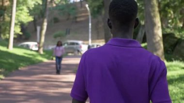 Genç Afrikalı arkadaşlar parkta buluşup sarılıyorlar.