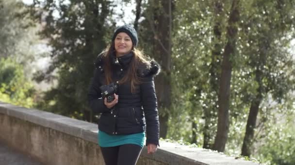 公園でカメラを持つ若い女性のポルタリットがカメラに向かって回り 微笑む — ストック動画