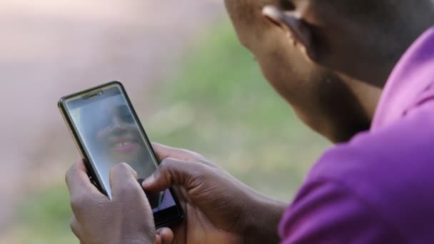 スマートフォンでガールフレンドを探している黒人アメリカ人の男 — ストック動画