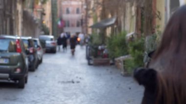 Kızgın, tehditkar kadının portresi. Kapüşonlu, ağır çekimde dışarı çıkıyor.