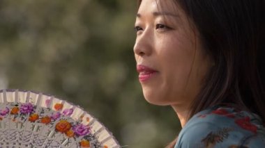 Güzel Çinli kadın yazın hayranını sallıyor.sıcak, sıcak-yavaş hareket