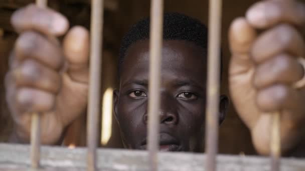 Jeune Homme Africain Derrière Les Barreaux Regardant Caméra Immigration Clandestine — Video