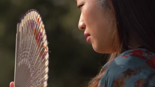 Young Chinese Woman Feeling Hot Waving Fan Slow Motion Outdoor — Stock Video