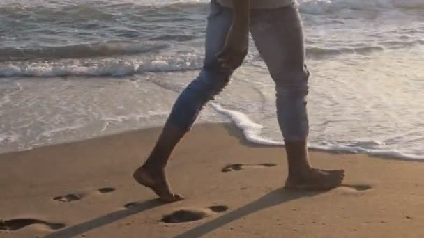 非洲男子的腿在日落时分在沙滩上行走 放松慢动作 — 图库视频影像