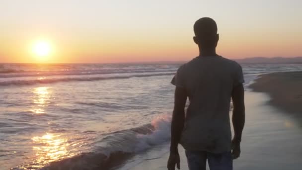 Νεαρός Αφρικανός Περπατάει Μόνος Του Στην Παραλία Ηλιοβασίλεμα Ελευθερία Αφέλεια — Αρχείο Βίντεο