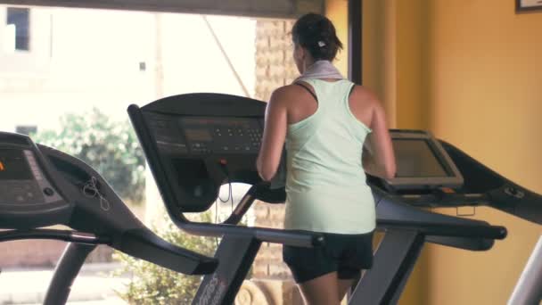 ジムスローモーションでトレッドミルで走っている美しい若いフィット女性 — ストック動画