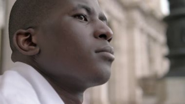 düşünceli ve umutlu Afrikalı Amerikalı genç adam gökyüzüne bakarak