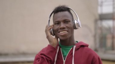 Genç siyah Afrika şehirde müzik dinliyor. İletişim, teknoloji