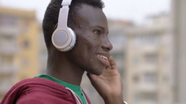 Genç siyah Afrika şehirde müzik dinliyor. İletişim, teknoloji