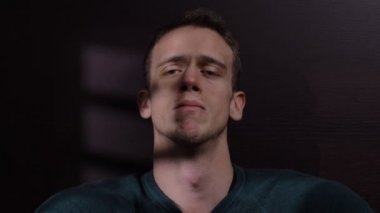 Üzgün yalnız çekici adam karanlıkta ağlıyor oturan, onun kayıp aşk düşünme