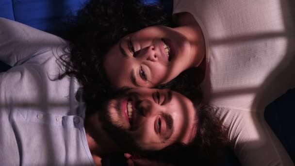 Νεαρό Χαμογελαστό Ζευγάρι Ξαπλωμένο Στο Κρεβάτι Κουβεντιάζοντας — Αρχείο Βίντεο