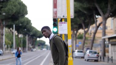 Sokakta sırt çantalı takım elbiseli bir adam.