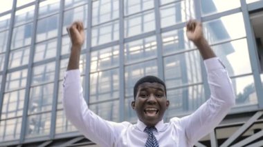 Kolları havada, takım elbiseli bir gencin portresi.