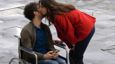 Empatik bir kadın ve tekerlekli sandalyede arkadaşı.