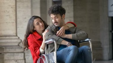 Empatik bir kadın ve tekerlekli sandalyede arkadaşı.