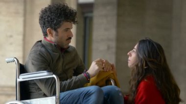 Empatik bir kadın ve tekerlekli sandalyede arkadaşı.