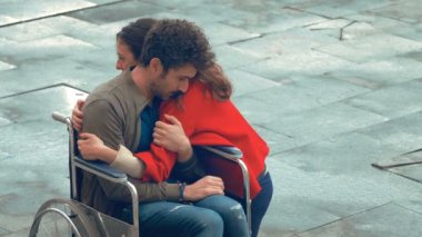 Empatik bir kadın ve tekerlekli sandalyede arkadaşı.