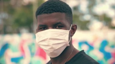 Cerrahi maske takan genç bir Afrikalı.