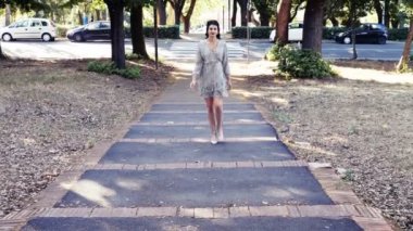 Modellik yaparak yürüyen zarif genç bir kadın.