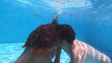 Havuzda aşk - su altında yüzen genç çift