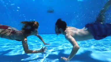 Havuzda aşk - su altında yüzen genç çift