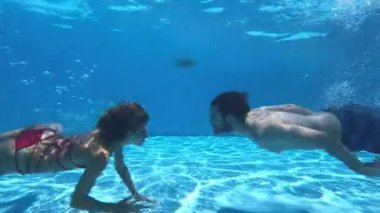 Havuzda aşk - su altında yüzen genç çift