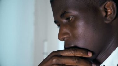 Düşünceli yakışıklı siyahi Afrikalı iş adamı ofisinde düşünüyor.
