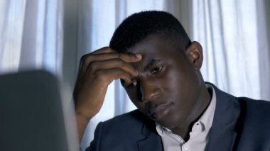 Üzgün, kendine güvenen, karanlıkta yalnız siyah adam, kameraya bakıyor.