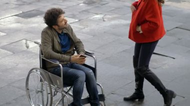 Tekerlekli sandalyesi olan genç adam.