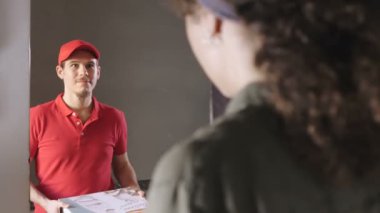 Bir kurye, genç bir bayana pizza getiriyor. Covid 19
