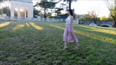 Modellik yaparak yürüyen zarif genç bir kadın.