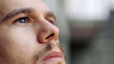 Demiryolunda oturan üzgün genç adam. 
