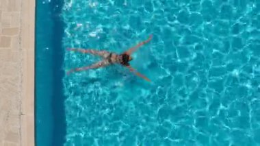 Havuzda kurbağalama yüzen atletik kadın manzarası.