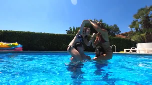 Δύο Κορίτσια Στις Πλάτες Των Φίλων Τους Παίζουν Στην Πισίνα — Αρχείο Βίντεο