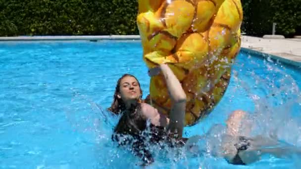 夏のゲーム 笑顔の女の子はプールで彼女の友人のインフレータブルを転覆 — ストック動画