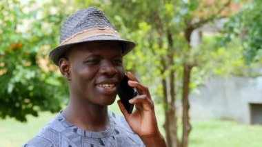 Şehirde akıllı telefon kullanan Afro-Amerikan bir adam. Yakışıklı delikanlı iletişim kuruyor.