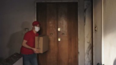 covid 19, 2020 - cerrahi maskeli genç binicinin portresi kameraya bakan bir paket teslim ediyor.