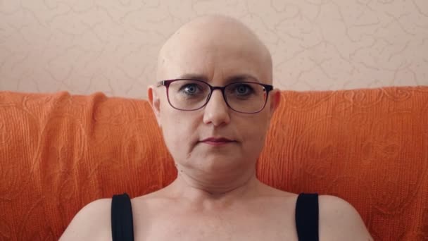 Serious Bald Woman Sitting Sofa Staring Camera — 图库视频影像