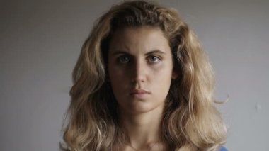 Cerrahi maske takan genç bir kadın kameraya bakıyor. Corona virüsü.