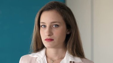 Genç ve güzel iş kadını kameraya gülümsüyor.