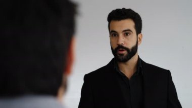 Genç yönetici iş arkadaşlarına yeni şirket politikasını anlatıyor.