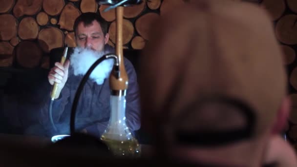 남자는 술집에서 물 담 뱃 대를 연기가 난다. 슬로우 모션. — 비디오