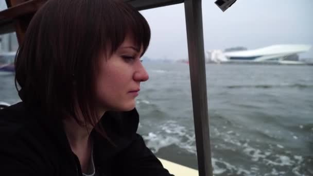 Girl sail on a boat through the canals in Amsterdam and looks out the window — Stock Video