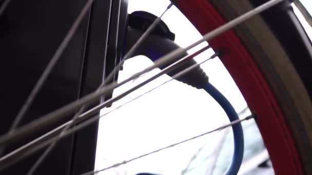 アムステルダムの自転車の車輪を背景に充電する電気自動車. — ストック動画